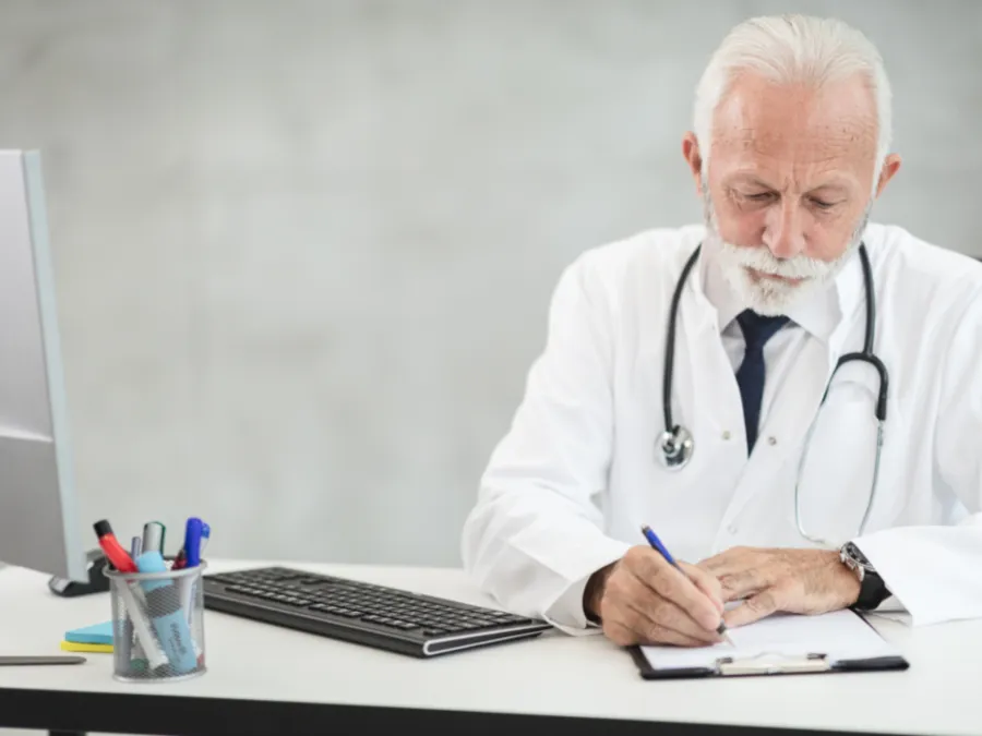 A doctor writing notes at a desk