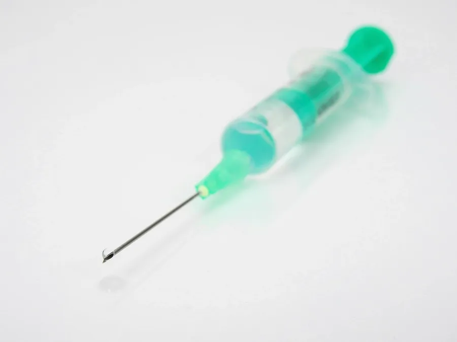 A prepared syringe resting on a white surface